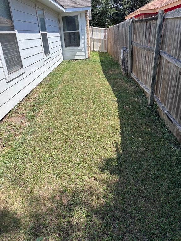 9656 Stonewood Drive, Dallas, TX 75227 Side yard featuring a wooden privacy fence, horizontal siding, and multiple windows