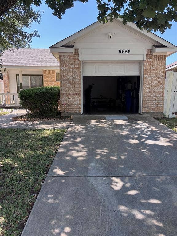9656 Stonewood Drive, Dallas, TX 75227 Exterior featuring a brick facade, white siding, and an attached garage with a white door