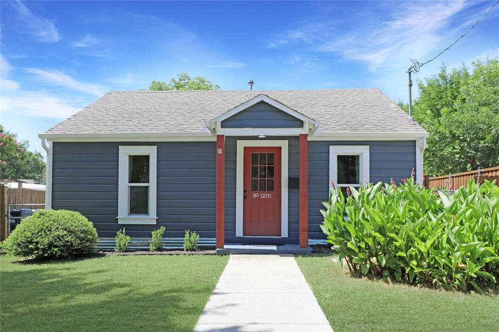 1201 1/2 Cole Street, McKinney, TX 75069 Charming exterior featuring horizontal siding, a red entry door, white trim windows, a gray shingle roof, and a concrete walkway