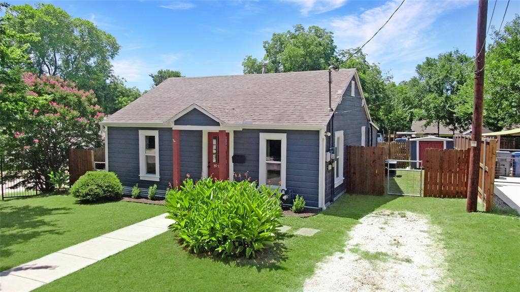 1201 1/2 Cole Street, McKinney, TX 75069 Charming bungalow exterior featuring dark blue siding with white trim, a red front door, and a brown shingle roof