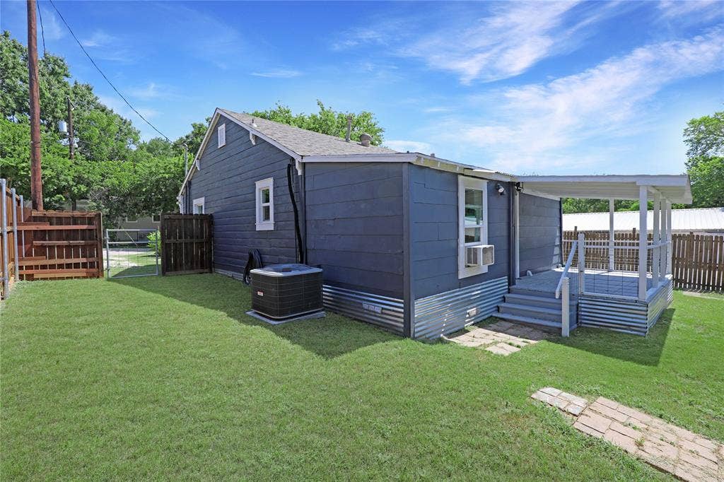 1201 1/2 Cole Street, McKinney, TX 75069 Exterior featuring blue siding, white window trim, and a covered back porch with steps