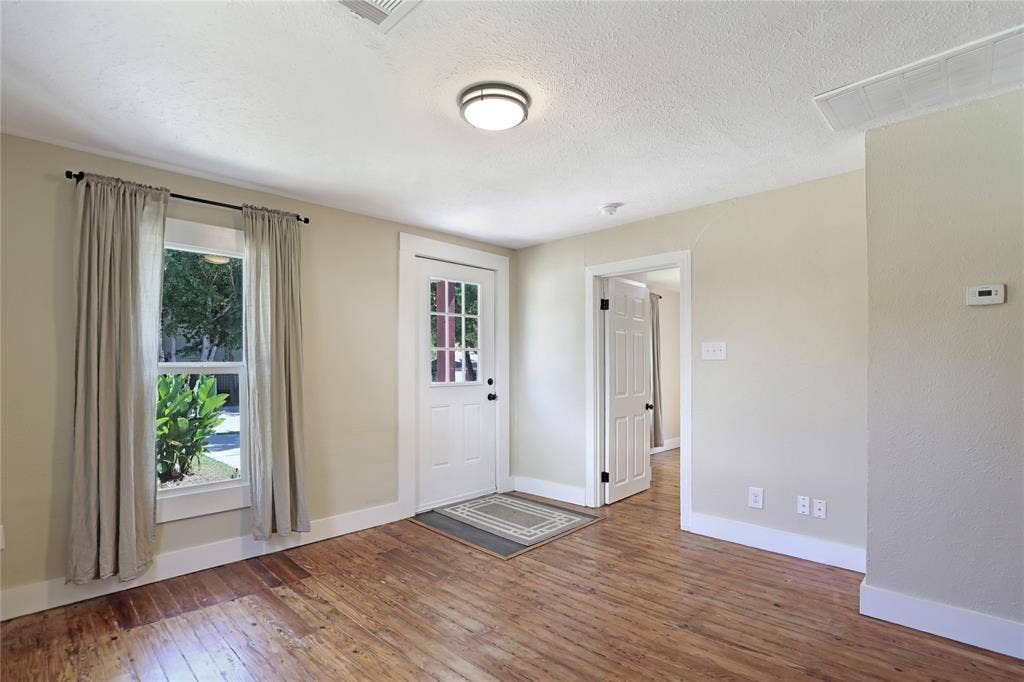 1201 1/2 Cole Street, McKinney, TX 75069 Entry area featuring wood-finish flooring, a white paneled door with glass inserts, and a single-pane window with white trim