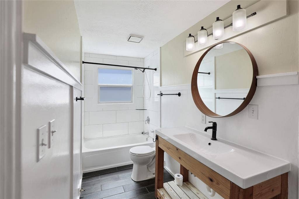 1201 1/2 Cole Street, McKinney, TX 75069 Bathroom featuring a wood-finish vanity with an integrated basin sink and matte black faucet