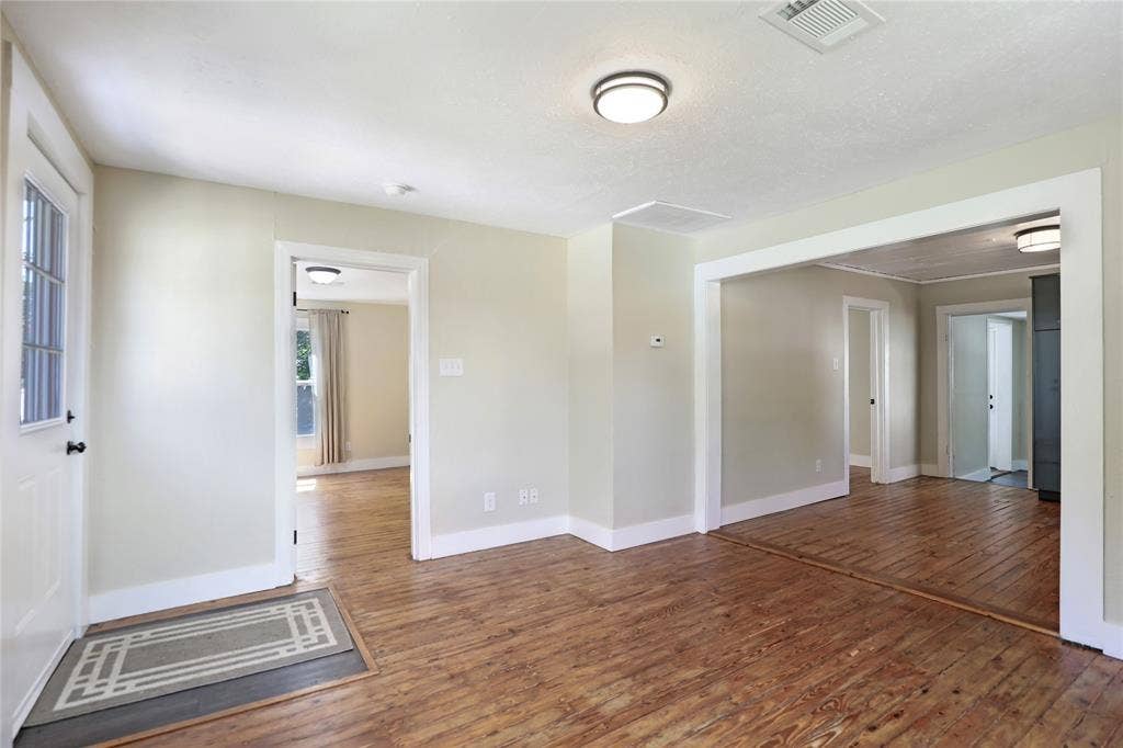 1201 1/2 Cole Street, McKinney, TX 75069 Distressed wood-finish flooring extends through multiple rooms with light-toned walls and white trim