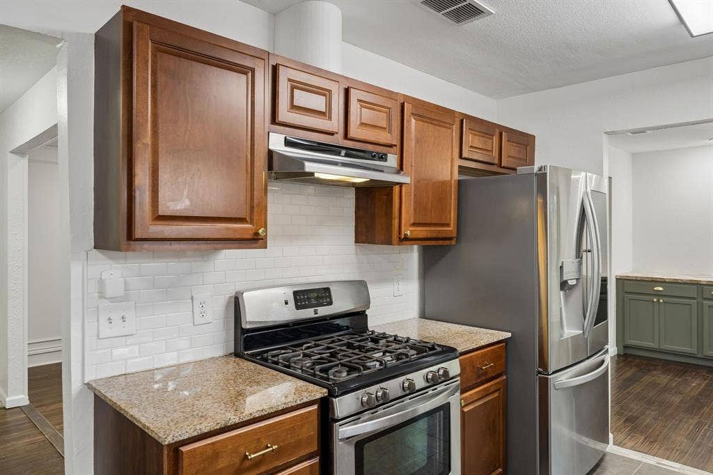 3624 Churchill Lane, Plano, TX 75075 Warm wood cabinetry provides generous storage, while updated counters, backsplash and appliances add practical appeal.