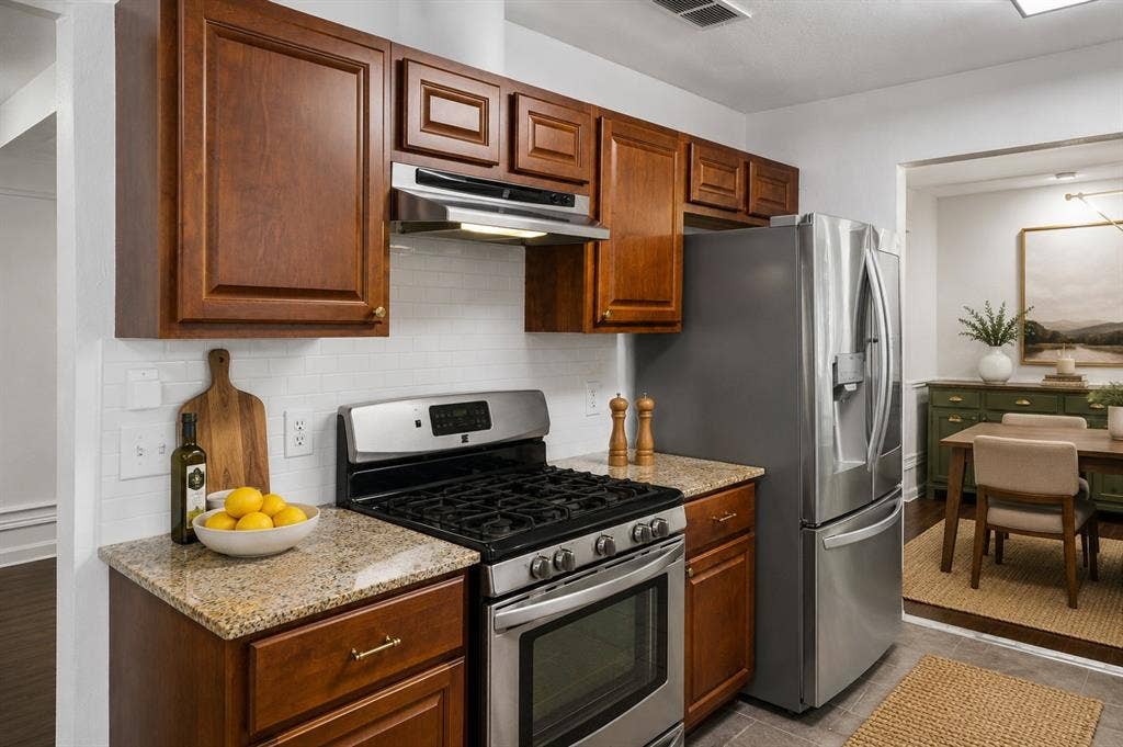 3624 Churchill Lane, Plano, TX 75075 Granite countertops, stainless steel appliances and a classic white subway tile backsplash create a functional foundation for everyday cooking.Virtually Staged -- original image may have been altered by AI.