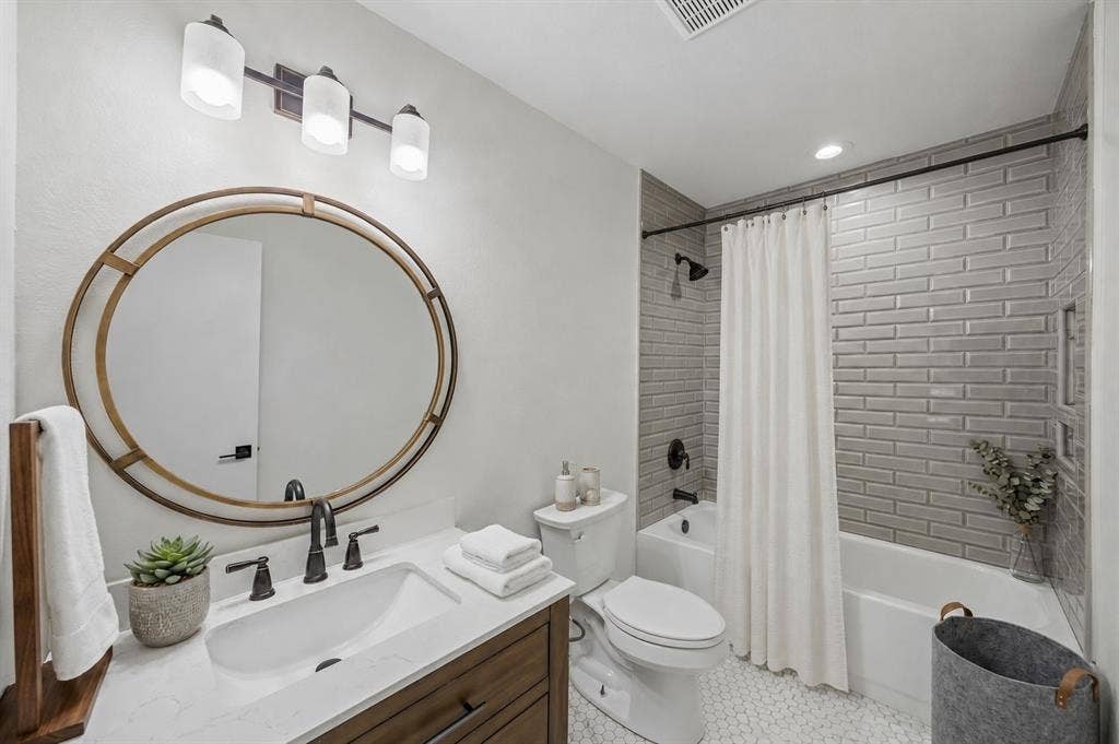 3624 Churchill Lane, Plano, TX 75075 The renovated guest bath features a furniture-style vanity, quartz countertop, designer hex tile flooring and a tiled shower surround.Virtually Staged -- original image may have been altered by AI.