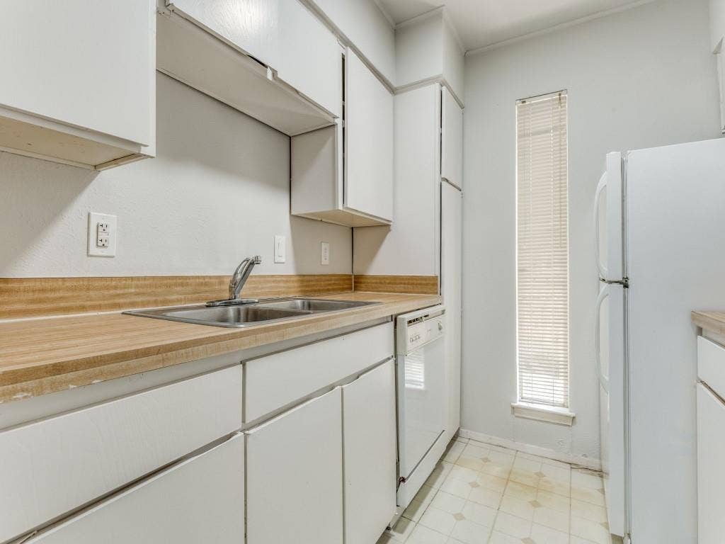 12888 Montfort Drive, #155, Dallas, TX 75230 Kitchen featuring white cabinetry, a double basin stainless steel sink, wood-finish countertops, and a full-size refrigerator