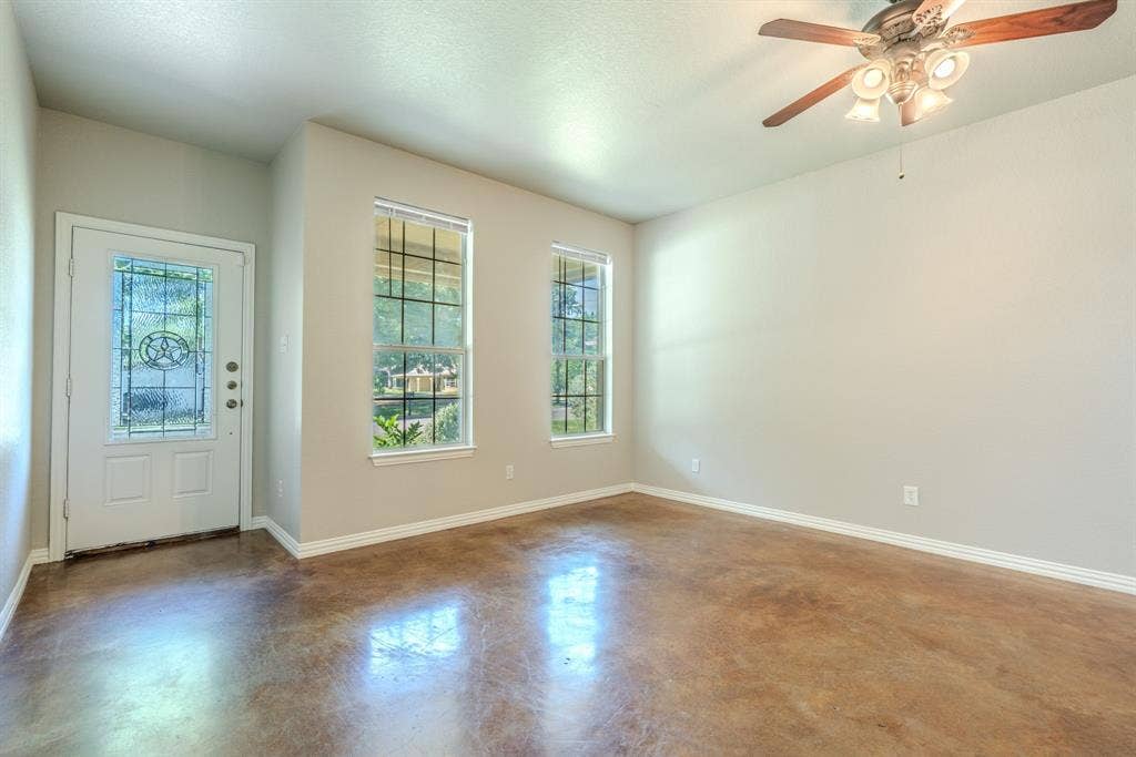 403 Summer Tree Lane, Springtown, TX 76082 Living room featuring entry, natural lighting, ceiling fan, fresh paint and stained concrete flooring
