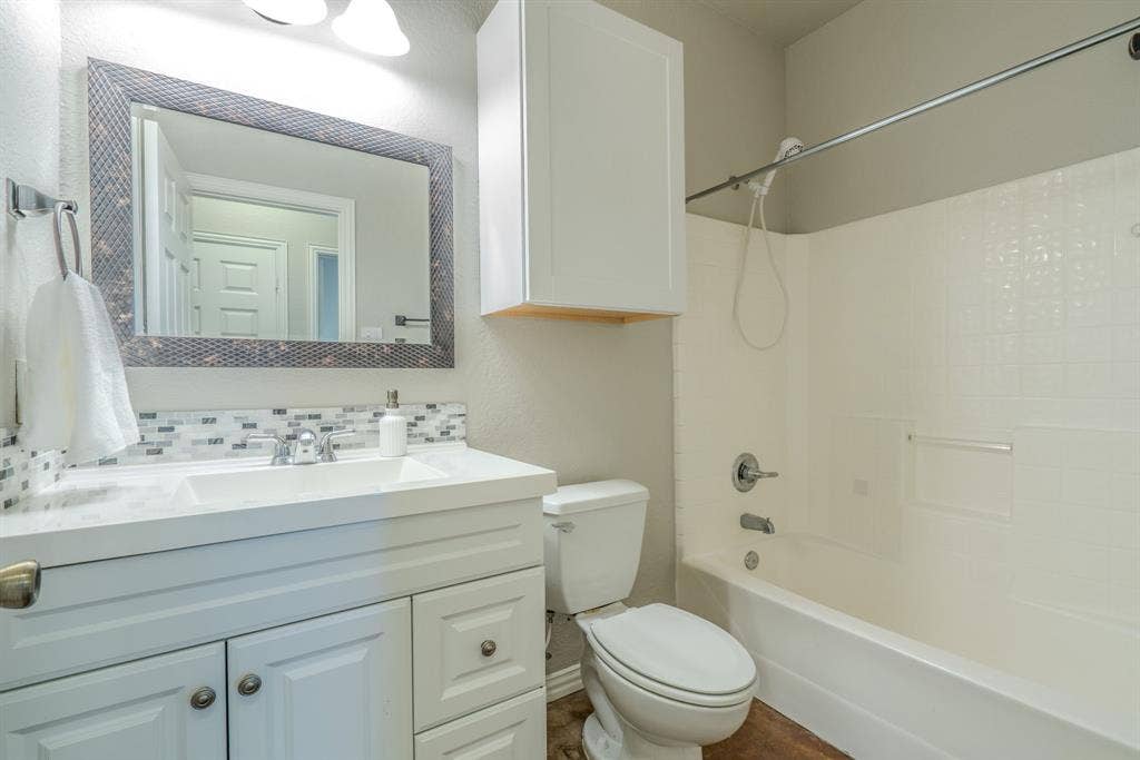 403 Summer Tree Lane, Springtown, TX 76082 Bathroom featuring a white vanity with a shower tub combo.