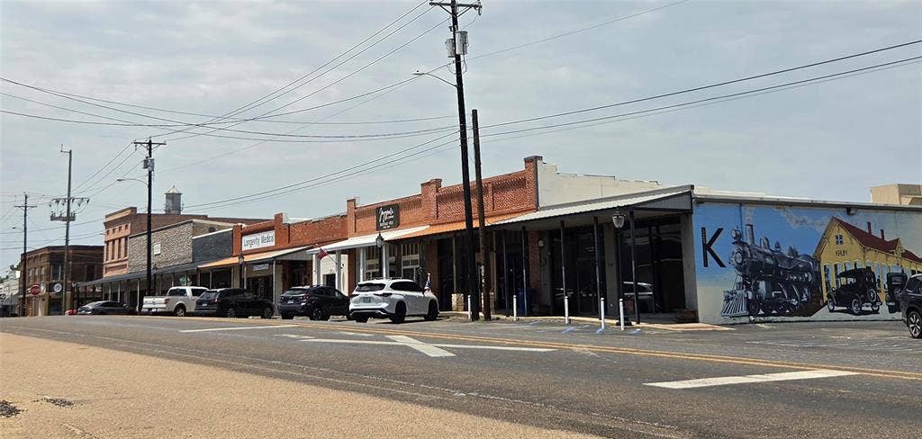 122 W Mccart Street, Krum, TX 76249 Commercial storefronts featuring brick and stone facades with awnings