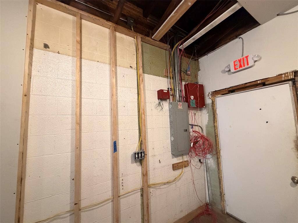 122 W Mccart Street, Krum, TX 76249 Wood studs before drywall installed and electrical box. Door leading to rear commercial space.