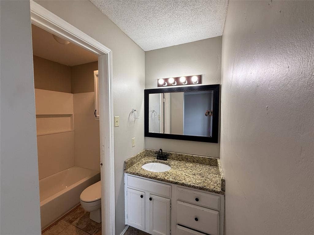 Bathroom featuring vanity, a textured ceiling, and tile patterned floors