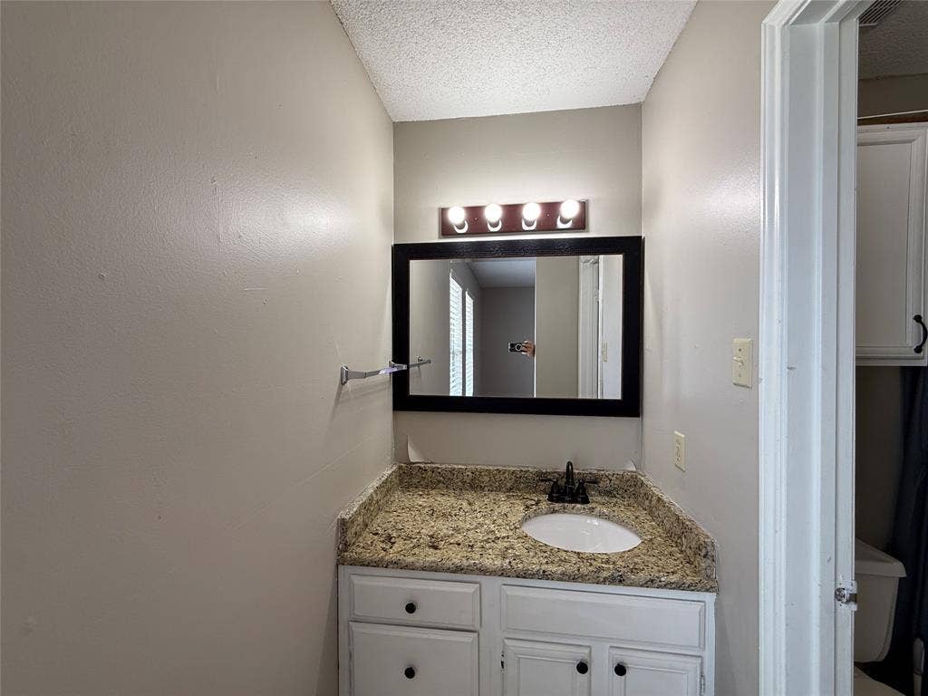 Bathroom featuring vanity and a textured ceiling