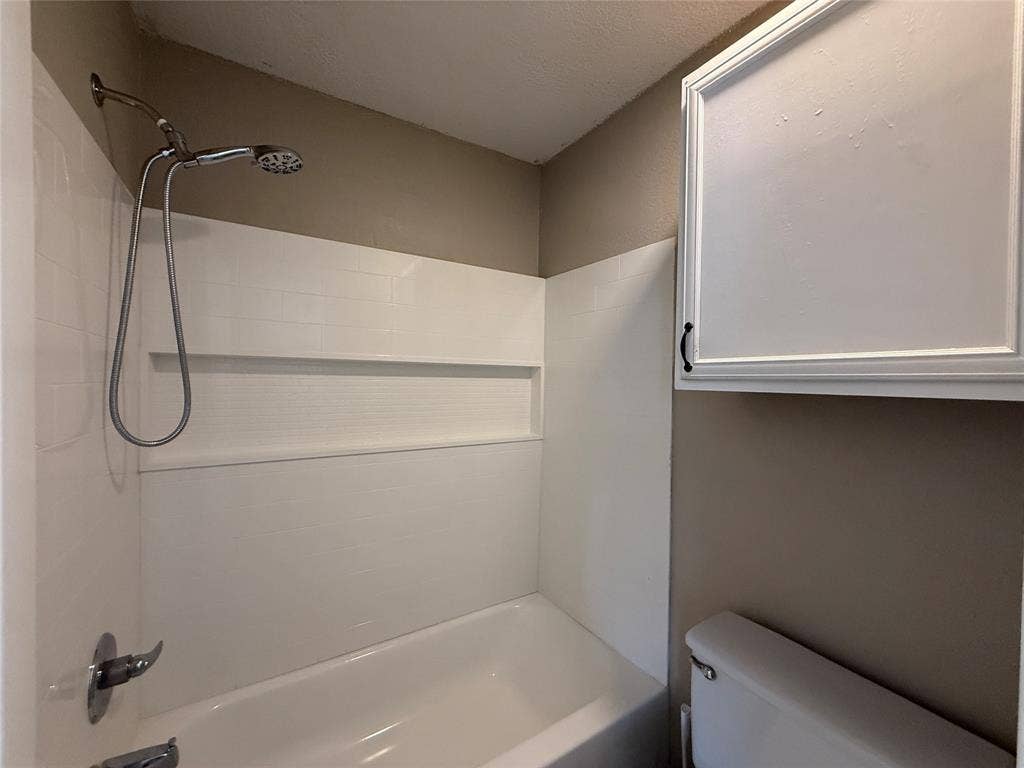 Full bathroom featuring toilet and shower / bathtub combination