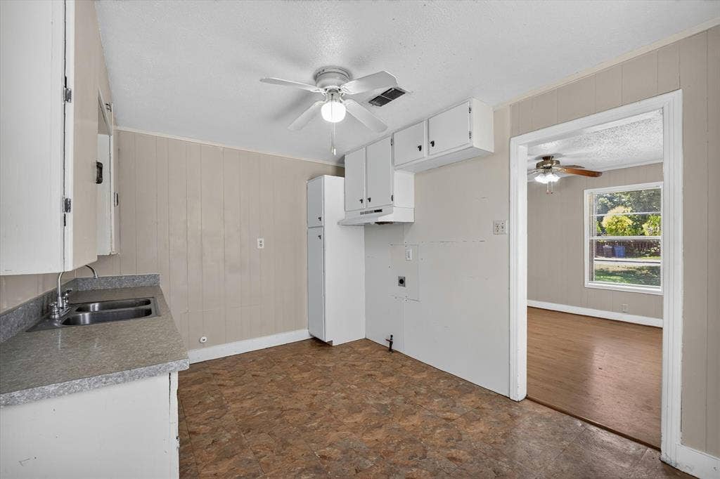 4450 Percy Street, Lancaster, TX 75134 Kitchen featuring white cabinetry, a double basin stainless steel sink, and gray speckled countertops