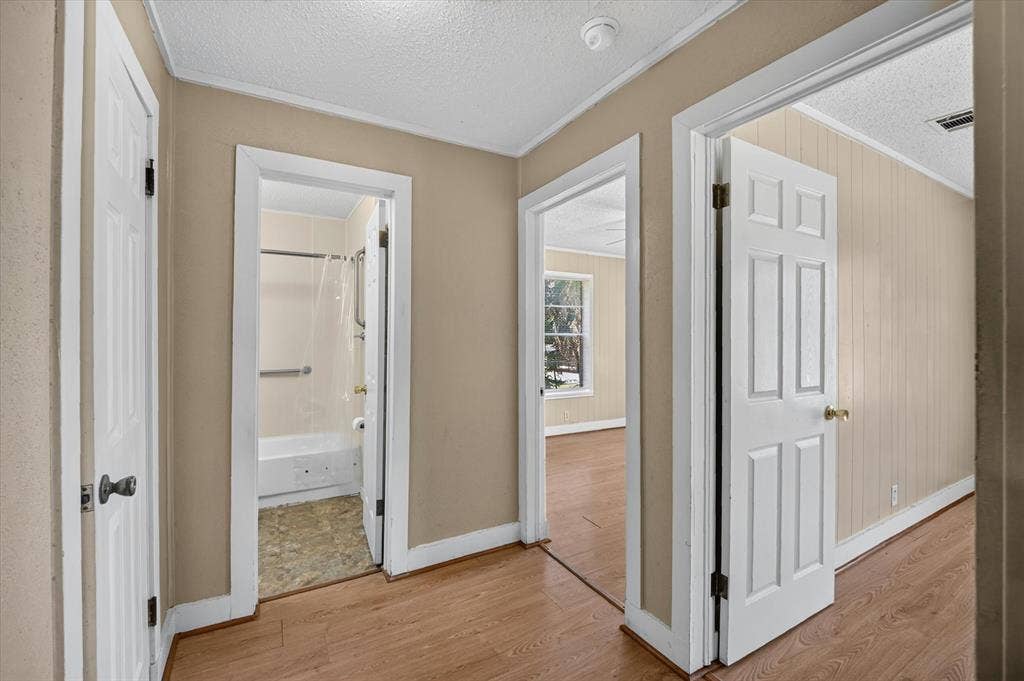 4450 Percy Street, Lancaster, TX 75134 Hallway featuring wood-finish flooring, neutral wall paint, and white trim
