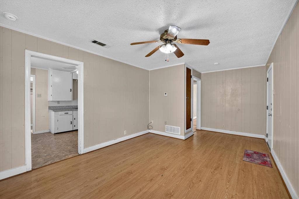 4450 Percy Street, Lancaster, TX 75134 Open concept living area featuring wood-finish flooring, neutral wall paneling, and a ceiling fan