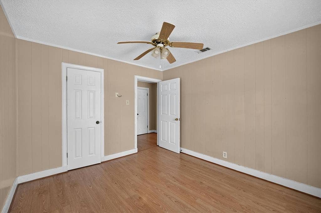 4450 Percy Street, Lancaster, TX 75134 Interior room featuring wood-finish flooring, light beige paneled walls, and white trim