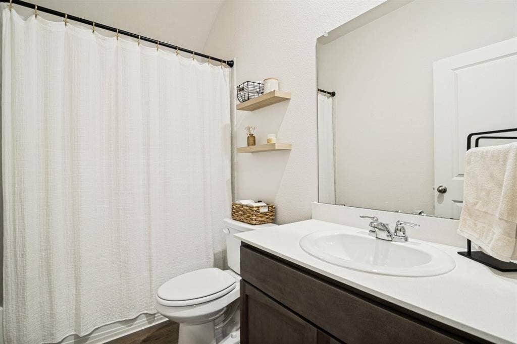 Bathroom featuring a dark wood-finish vanity with a white countertop and integrated sink