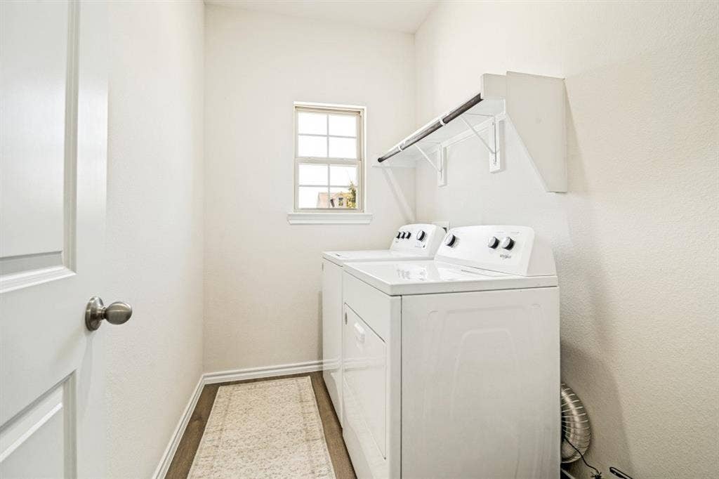 Dedicated utility room featuring wood-finish flooring, a window with natural light, and a functional hanging rod with shelving