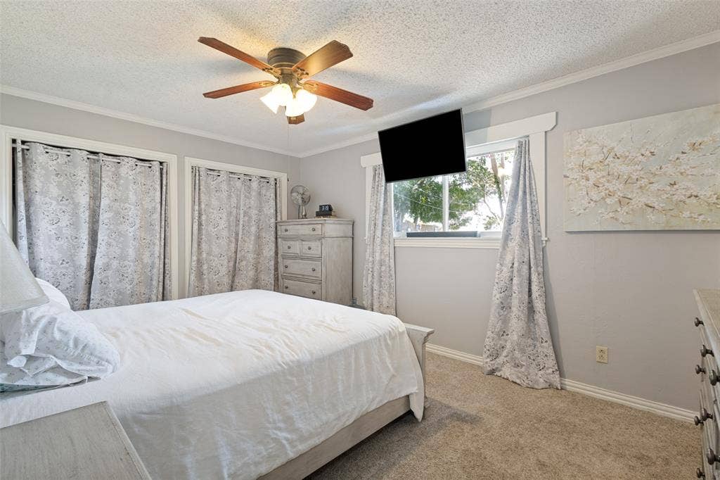 906 Clearview Street, Krum, TX 76249 Primary bedroom with a ceiling fan, two closet openings with curtain covering.