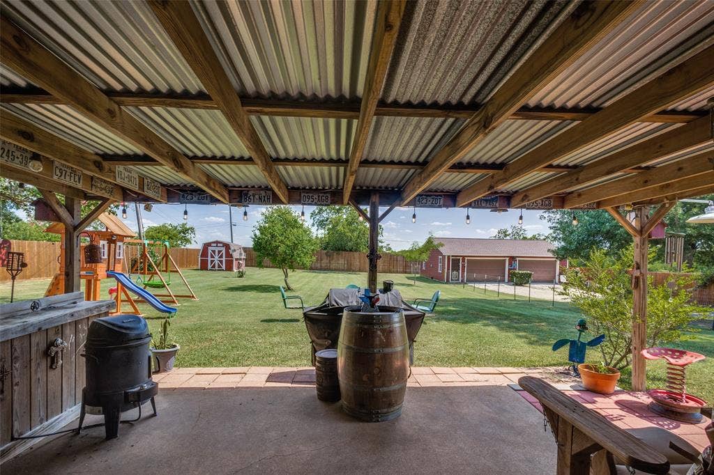 906 Clearview Street, Krum, TX 76249 Covered patio with a corrugated metal roof and exposed wood beams