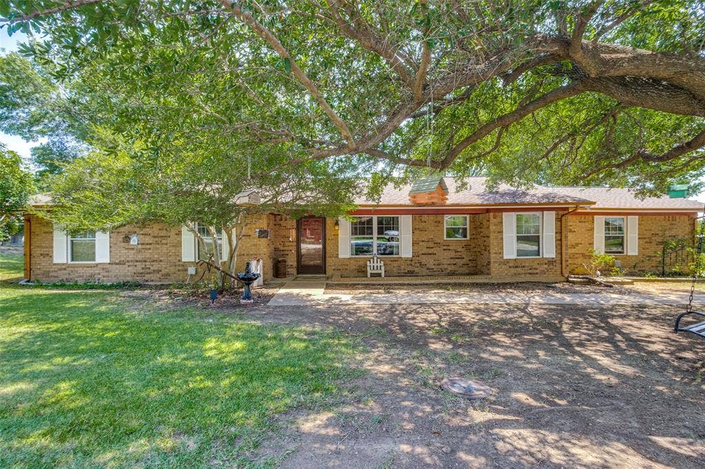 906 Clearview Street, Krum, TX 76249 Ranch-style exterior featuring white window shutters