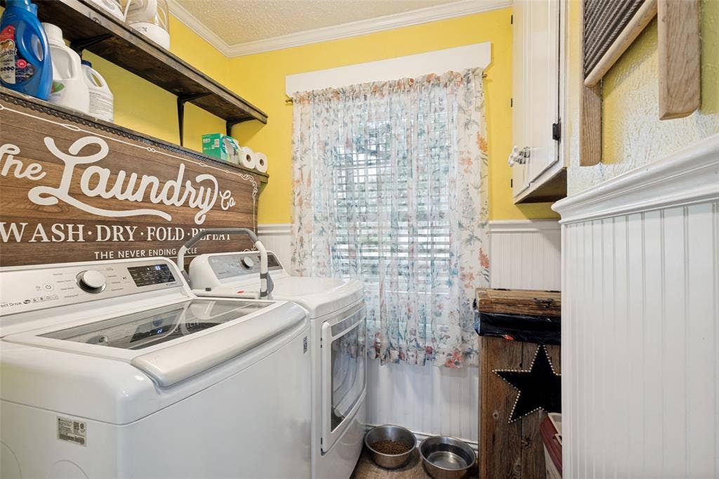 906 Clearview Street, Krum, TX 76249 Laundry area featuring wood-finish open shelving, beadboard wainscoting, and a window with blinds