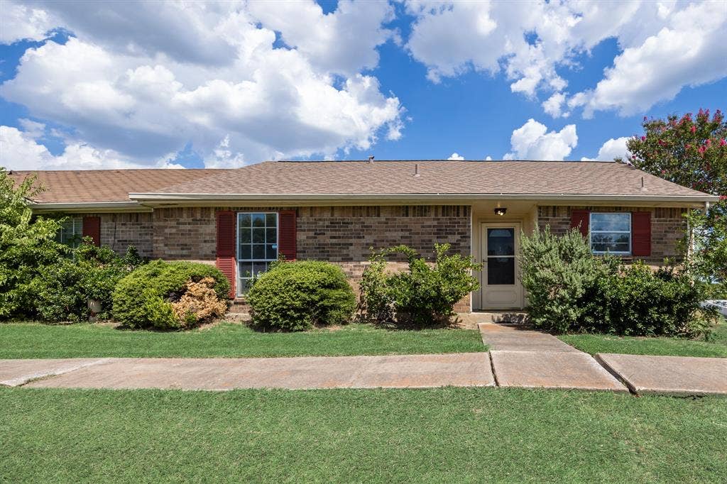 1 E Mountain Lane, #33, Grand Prairie, TX 75052 Brick exterior with a brown shingle roof, complemented by red shutters