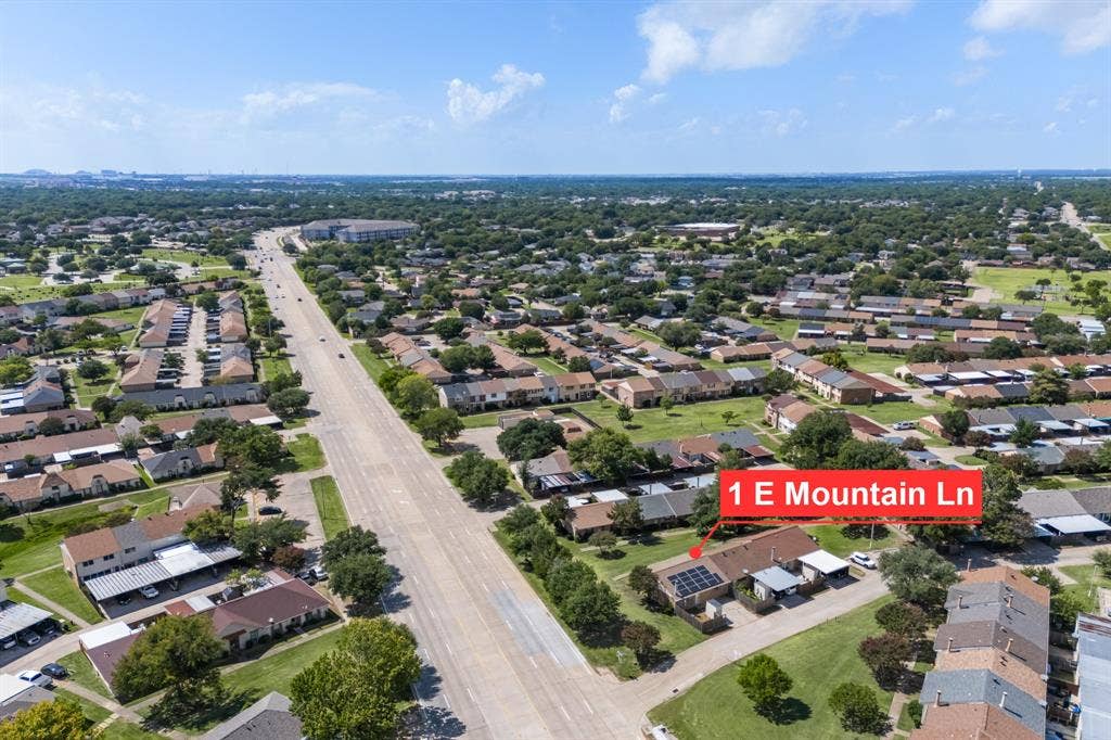 1 E Mountain Lane, #33, Grand Prairie, TX 75052 Aerial perspective showcasing a residential area with a main thoroughfare and dense tree coverage