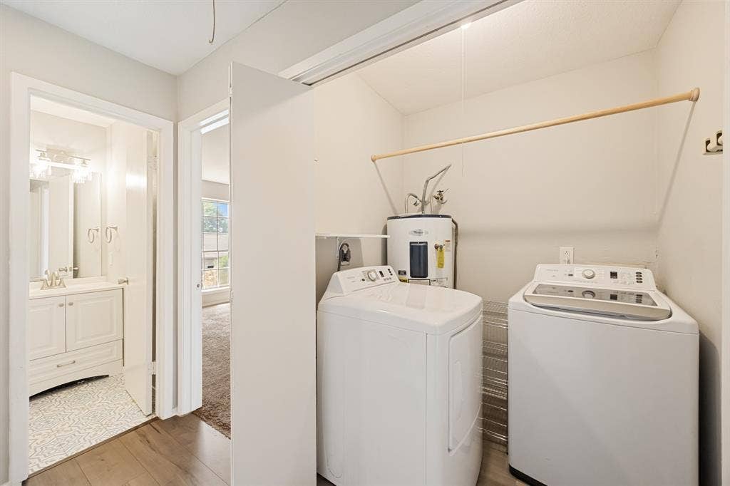1 E Mountain Lane, #33, Grand Prairie, TX 75052 Dedicated laundry area featuring a wooden drying rod, water heater, and wood-finish flooring