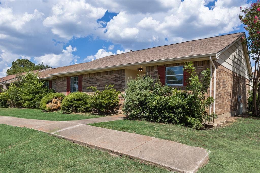 1 E Mountain Lane, #33, Grand Prairie, TX 75052 Brick exterior with a gabled roof and red window shutters