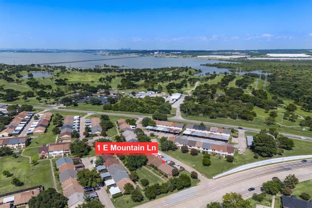 1 E Mountain Lane, #33, Grand Prairie, TX 75052 Aerial perspective highlighting the property amidst extensive green spaces and expansive water features