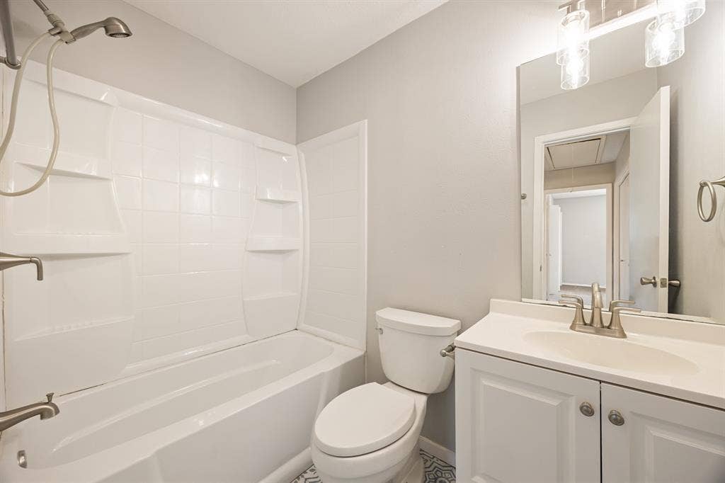 1 E Mountain Lane, #33, Grand Prairie, TX 75052 Bathroom featuring a white vanity with a single basin sink, brushed nickel faucet, and a wall-mounted mirror