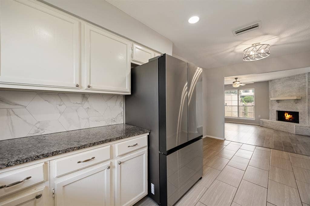 1 E Mountain Lane, #33, Grand Prairie, TX 75052 Kitchenette featuring white cabinetry, dark granite countertop, and hexagonal marble-look tile backsplash