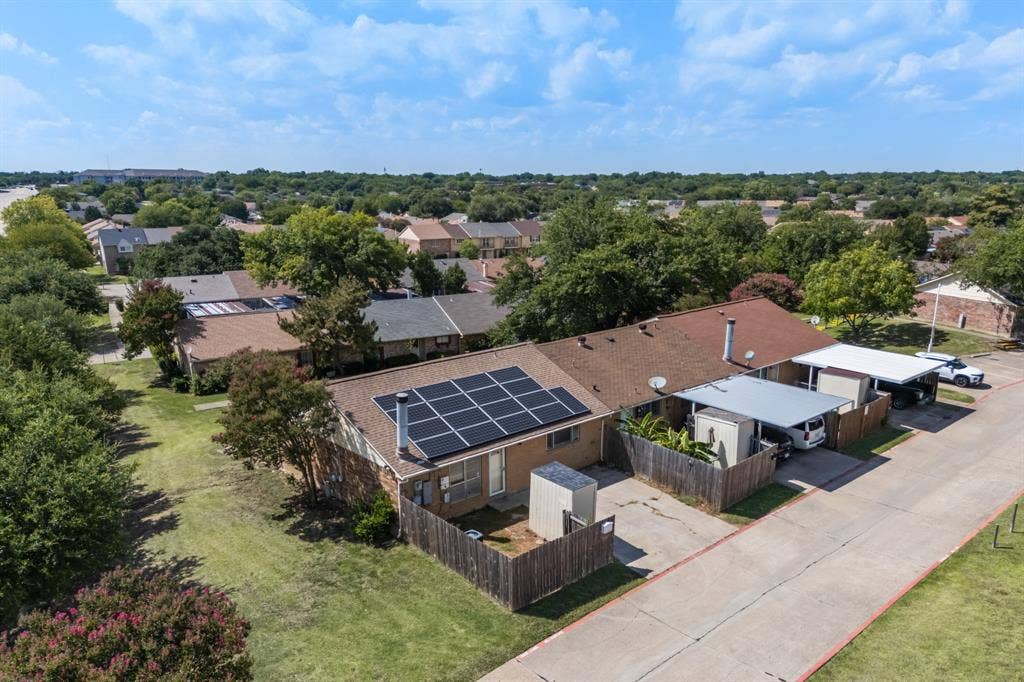 1 E Mountain Lane, #33, Grand Prairie, TX 75052 Residential property featuring an array of rooftop solar panels, a private fenced yard, and a covered carport