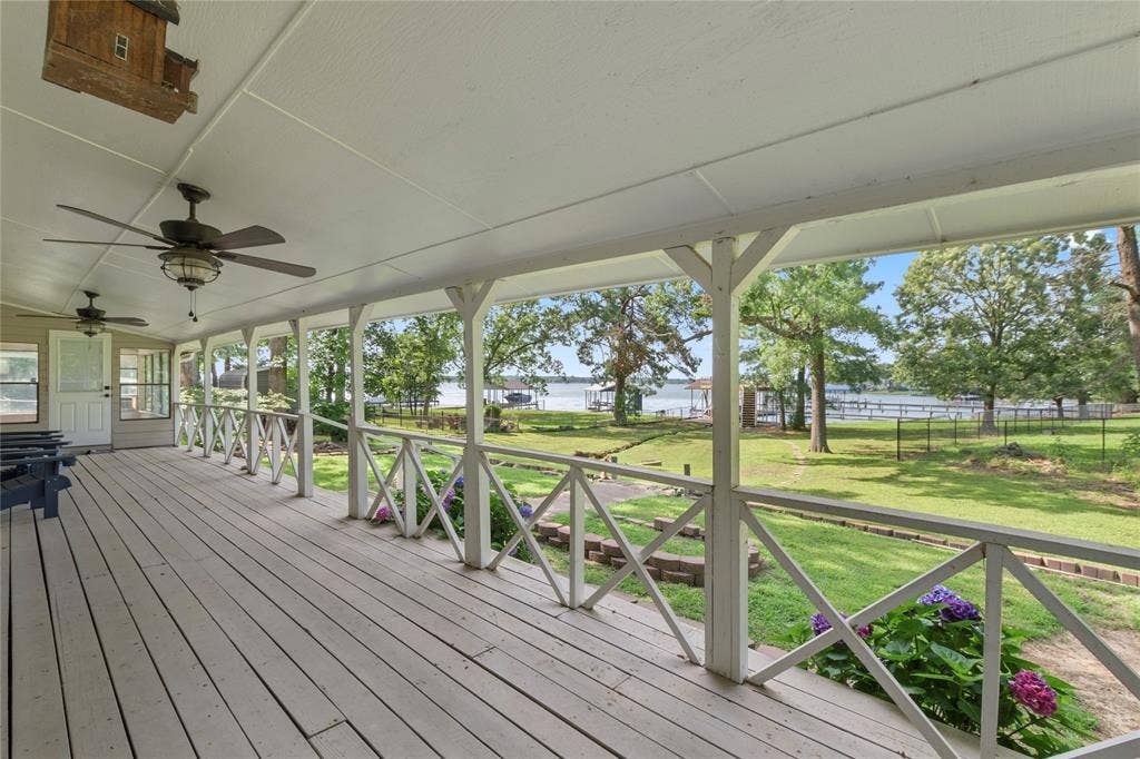 323 Dyer Circle, Payne Springs, TX 75156 Expansive covered porch featuring wood-finish flooring, multiple ceiling fans, and decorative railing