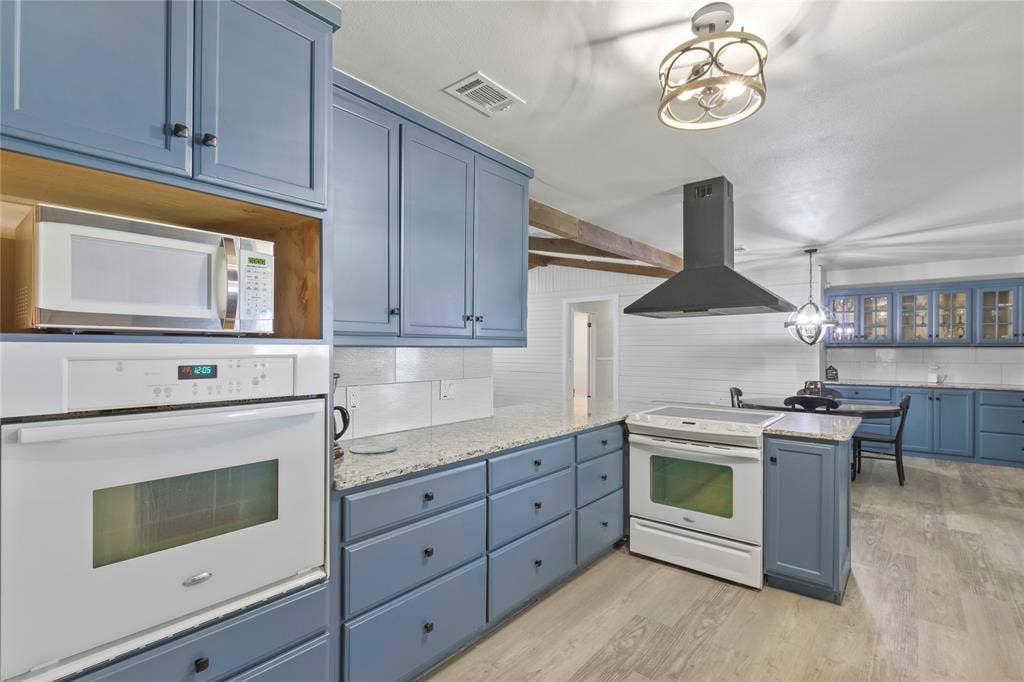 323 Dyer Circle, Payne Springs, TX 75156 Kitchen with blue cabinetry, light-colored countertops, and wood-finish flooring