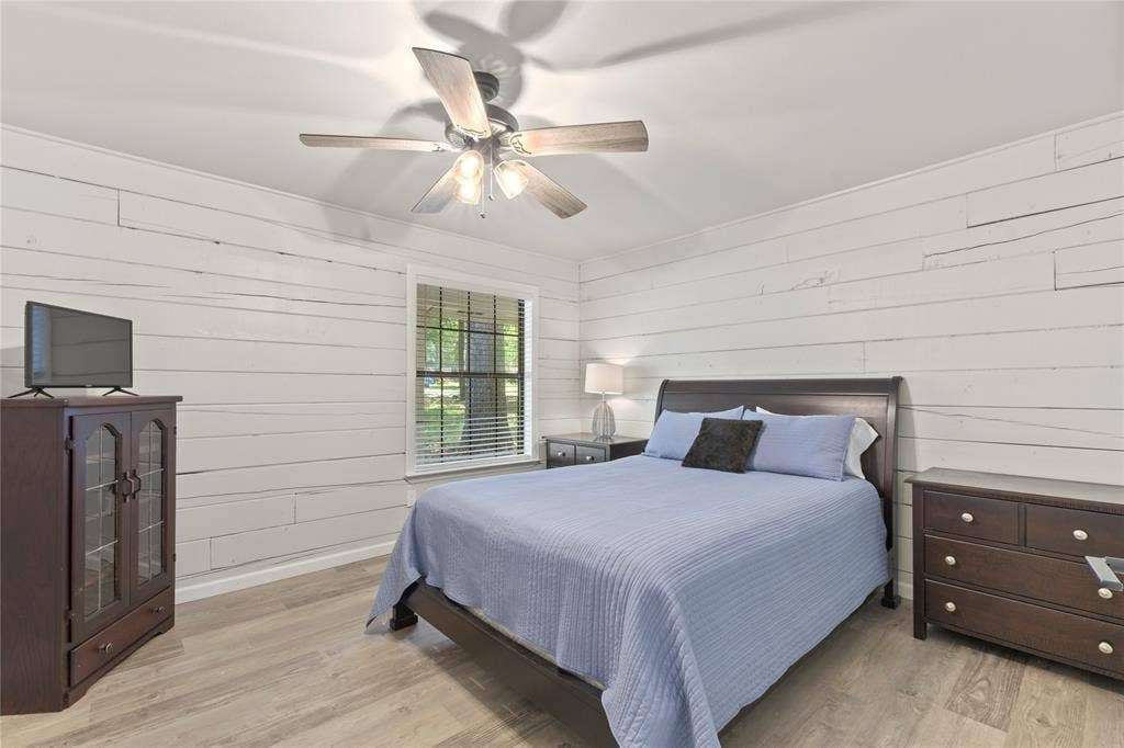 323 Dyer Circle, Payne Springs, TX 75156 Interior room featuring white horizontal plank walls and wood-finish flooring