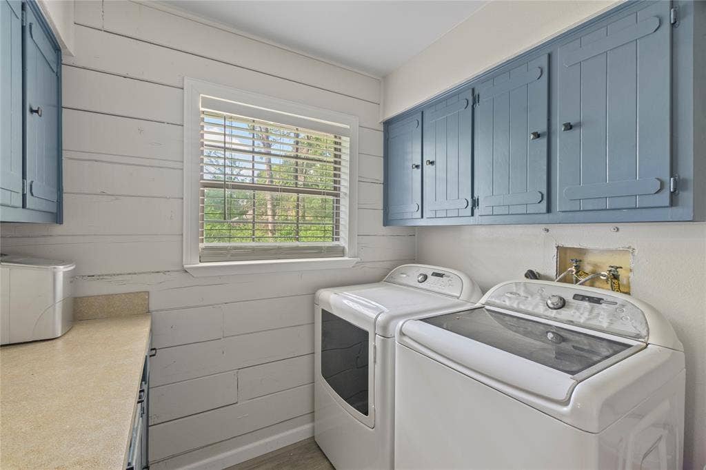 323 Dyer Circle, Payne Springs, TX 75156 Utility room featuring wood-plank accent wall, built-in cabinetry with blue finish, window with natural light, and countertop space