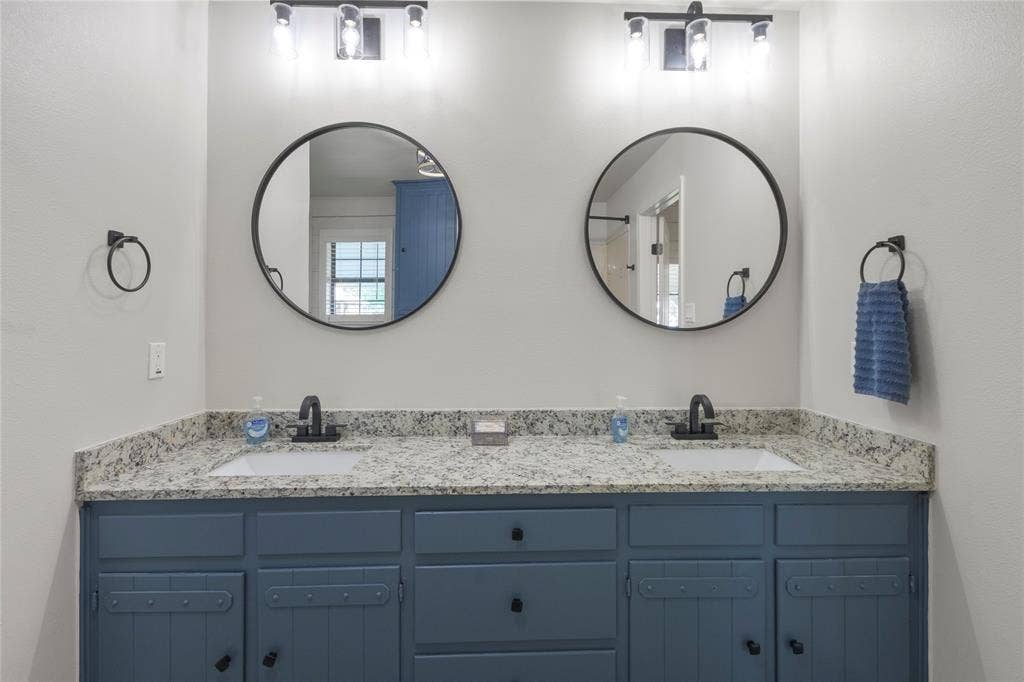 323 Dyer Circle, Payne Springs, TX 75156 Double vanity with a granite-look countertop, integrated sinks, and matte black fixtures