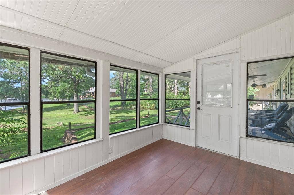 323 Dyer Circle, Payne Springs, TX 75156 Enclosed sunroom featuring multiple large windows, wood-finish flooring, and white paneled walls and ceiling