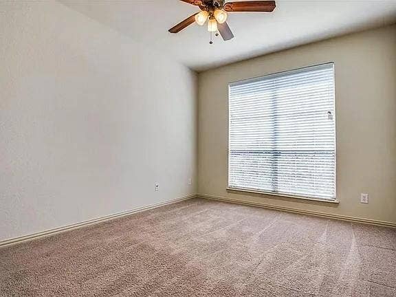 13990 Stevens Point Drive, Frisco, TX 75033 Neutral-toned wall finishes with a large window featuring blinds, complemented by a ceiling fan with integrated lighting