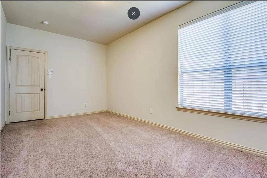 13990 Stevens Point Drive, Frisco, TX 75033 Carpeted interior room featuring a window with horizontal blinds, a panel door, and neutral wall paint