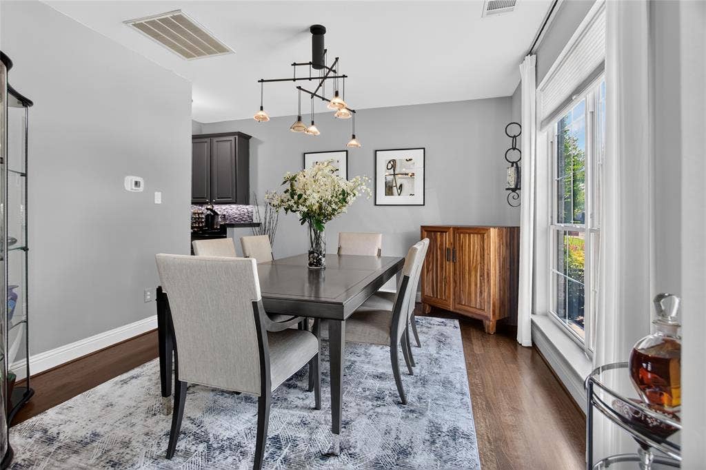 4243 Millview Lane, Dallas, TX 75287 View of dining area to the right as you enter the home. Statement light fixture. Wood floors, light soft grey walls. Window looks out onto the front landscaping. Entrance at the rear is pass through to the Kitchen.