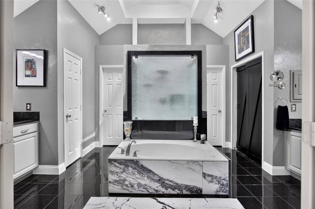4243 Millview Lane, Dallas, TX 75287 The primary bathroom is HUGE. Separate vanities and tile floor. Unwind in the luxurious marble surround soaking tube, creating a spa-like retreat. Skylights were added in 2017 bringing in the natural light.