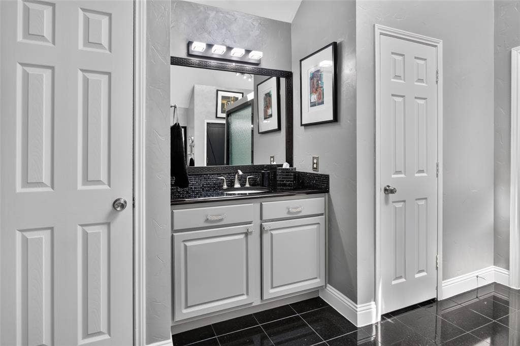 4243 Millview Lane, Dallas, TX 75287 Vanity opposite the longer vanity in the Primary bath. Granite counter, updated light fixture and faucet. Full linen closet as well.