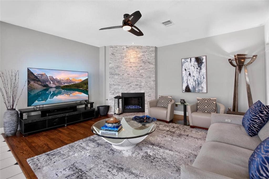 4243 Millview Lane, Dallas, TX 75287 View of the floor to ceiling natural split stone gas fireplace. Fireplace remodeled in 2017. Accent lighting enhances the beauty of the stone work.