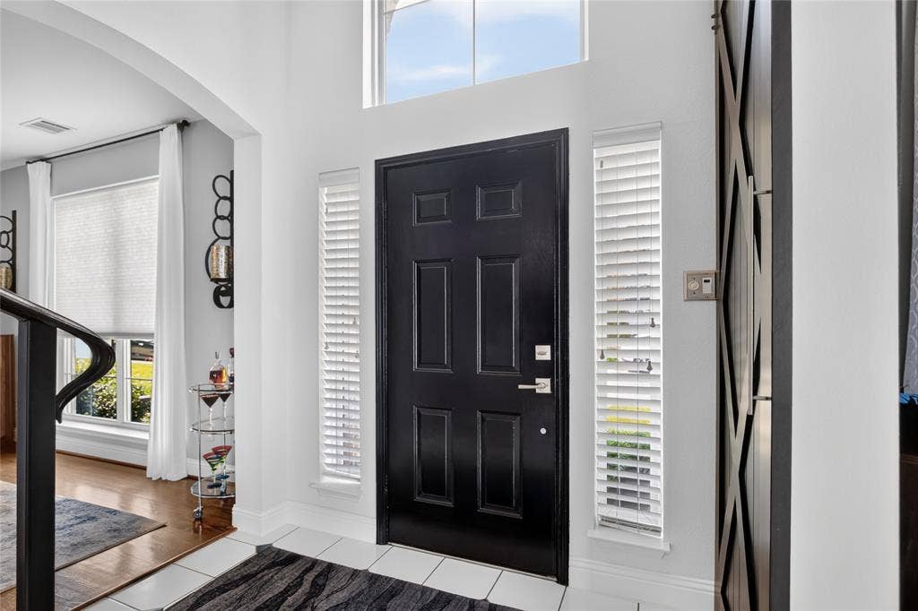 4243 Millview Lane, Dallas, TX 75287 2 story foyer with view of solid door with side windows. Dining room is off to the right as you enter and home office on your left.